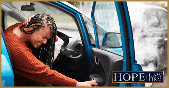 girl holding head after car accident