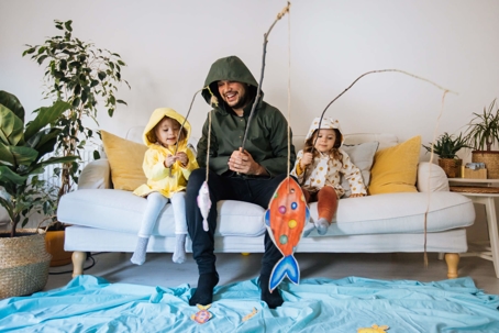 Father and kids pretend fishing in living room