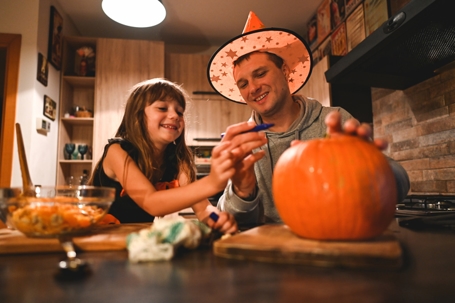 father and daughter carving pumpkins