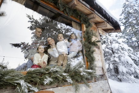 family watching snow fall in cabin